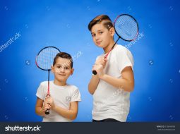 stock-photo-the-two-boys-with-badminton-rackets-outdoors-516846958